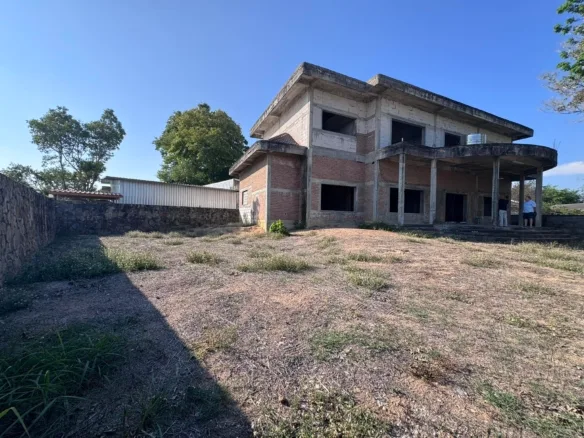 Abandoned brick building with overgrown courtyard and broken windows