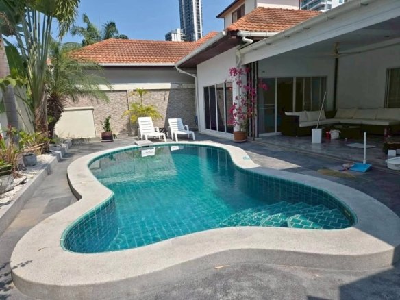 Luxury home with kidney-shaped swimming pool and tropical landscaping