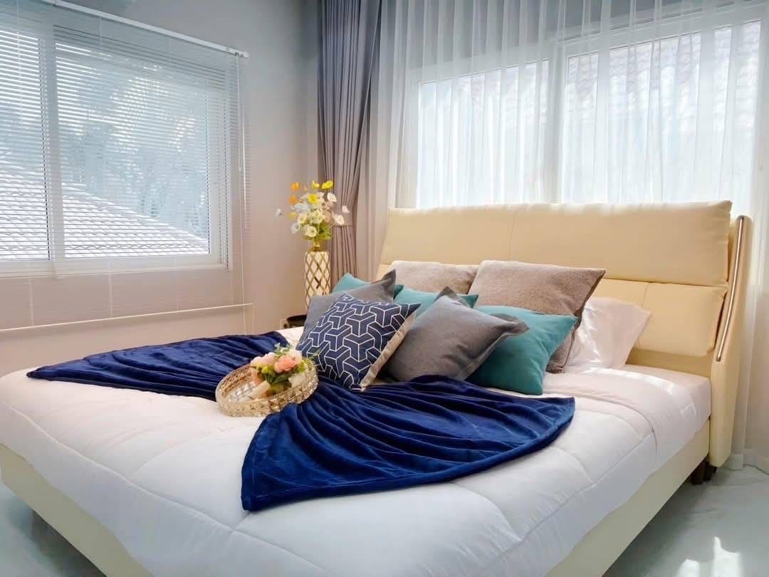 Pool Villa Central Park 4-2 (12) Modern bedroom with yellow headboard, blue throw blanket, and natural light from windows
