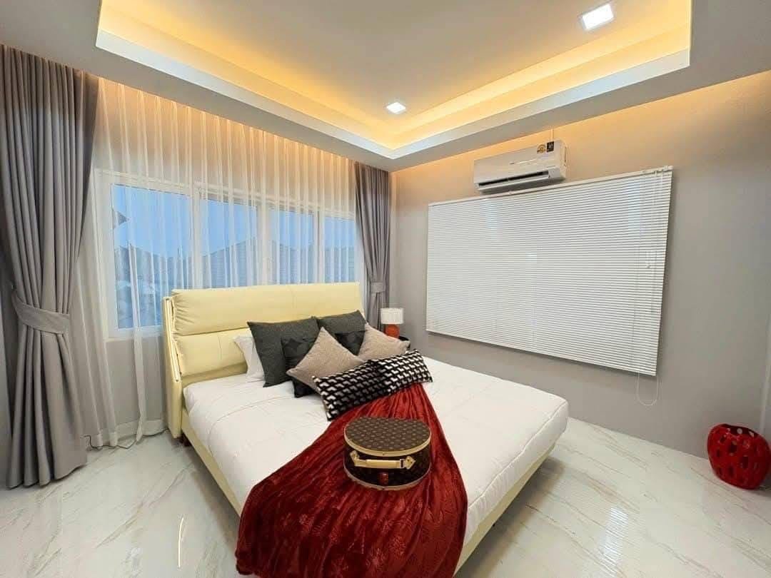 Pool Villa Central Park 4-2 (13) Modern bedroom with yellow headboard, white bed, red velvet bench, and cove lighting