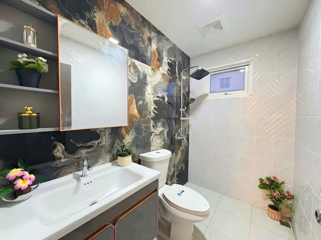 Pool Villa Central Park 4-2 (14) Modern bathroom with marble accent wall, white fixtures, and shower area