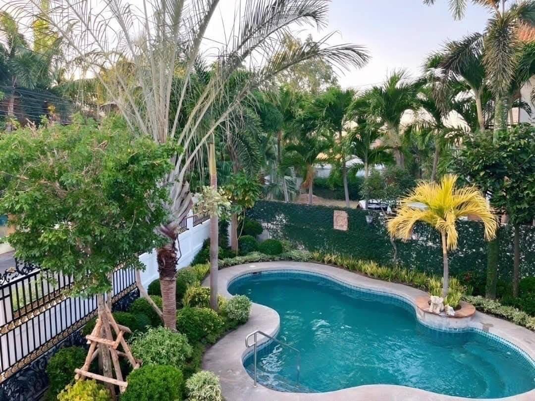 Pool Villa Central Park 4-2 (5) Luxury backyard pool surrounded by palm trees and lush tropical landscaping