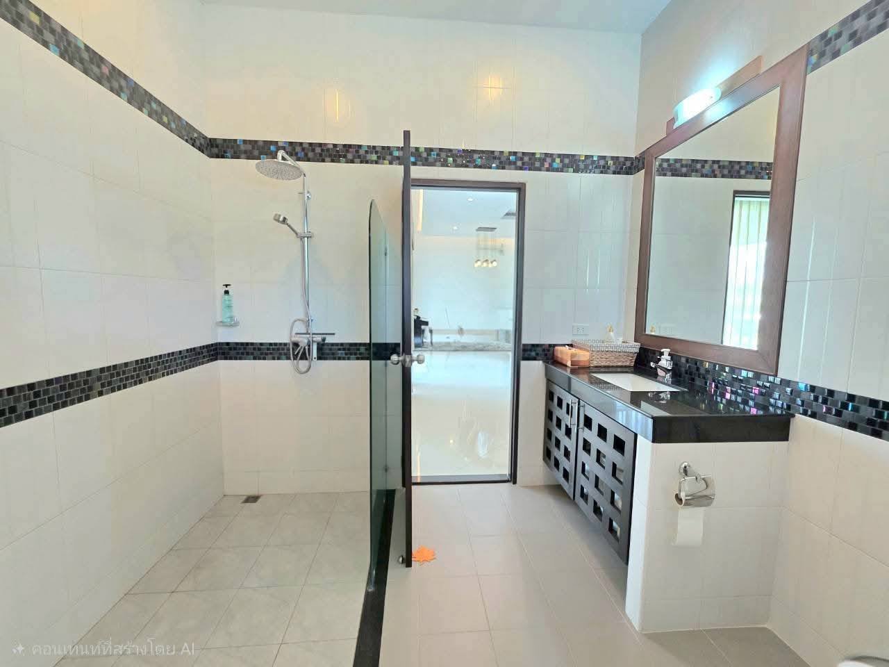 Spacious bathroom with glass-panel walk-in shower, black mosaic tile accents, dark vanity with vessel sink, and large framed mirror