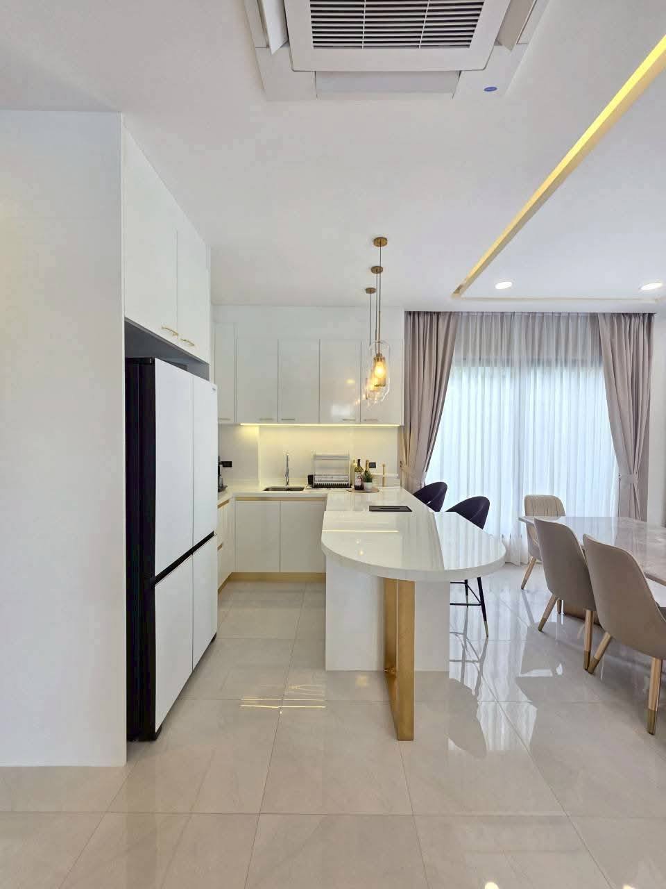 Modern kitchen with white cabinetry, island seating, and dining area