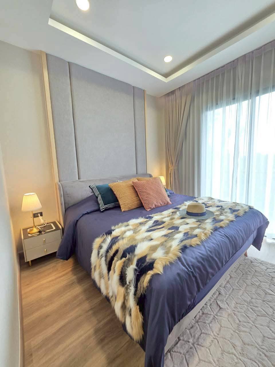 Modern bedroom with gray upholstered headboard and blue bedding
