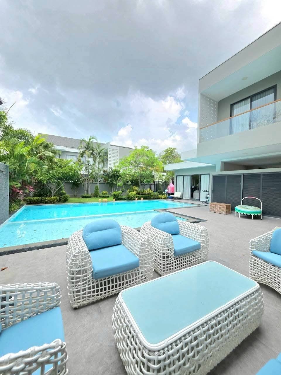 Modern luxury home with swimming pool and white wicker lounge seating area