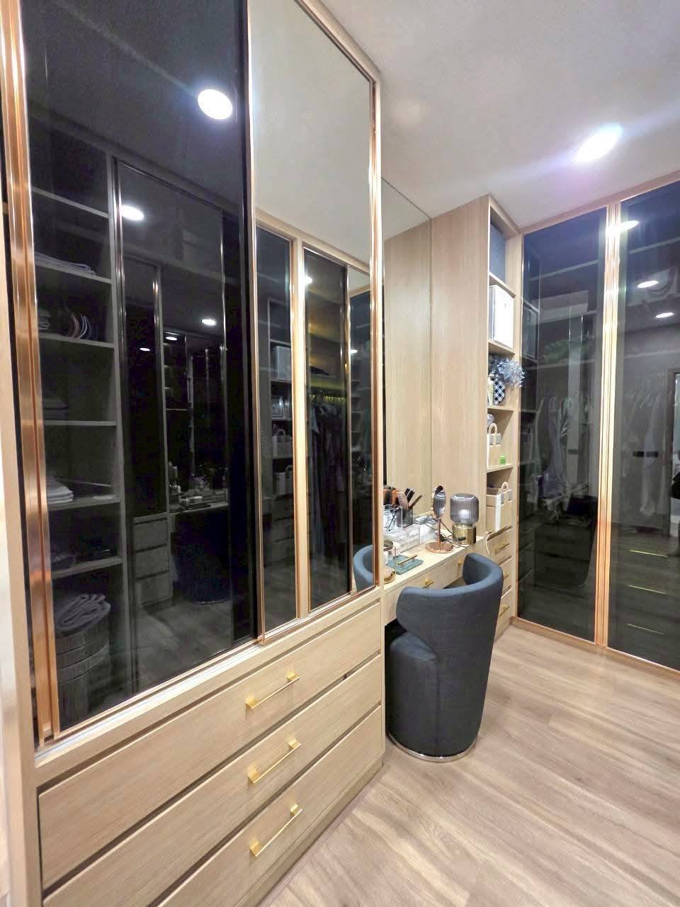 Modern walk-in closet with mirrored sliding doors and wooden storage cabinets