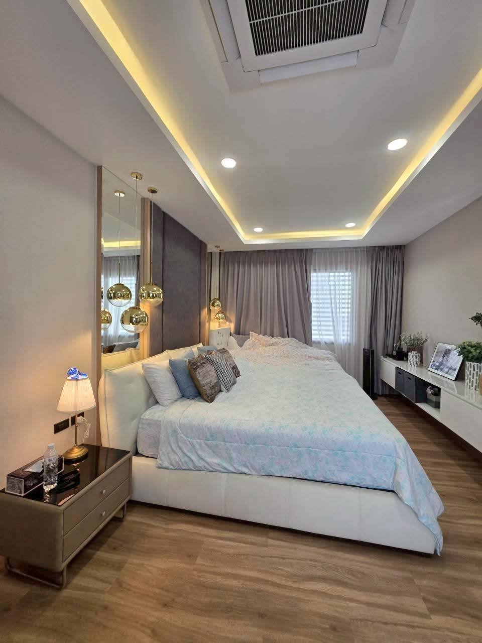 Modern luxury bedroom with cove lighting, pendant lamps, and city views