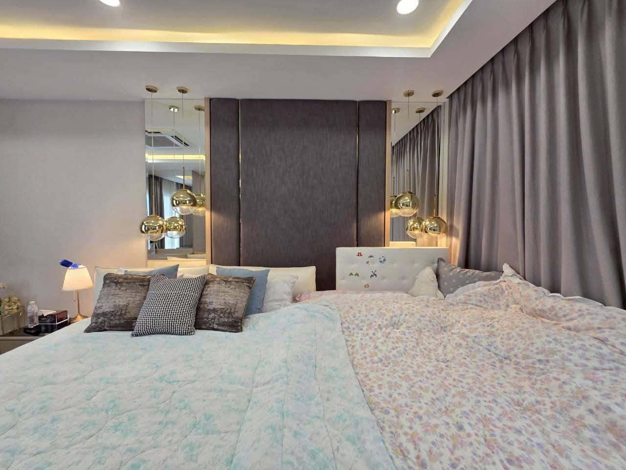 Modern luxury bedroom with dual beds, dark headboard, gold pendant lights, gray curtains