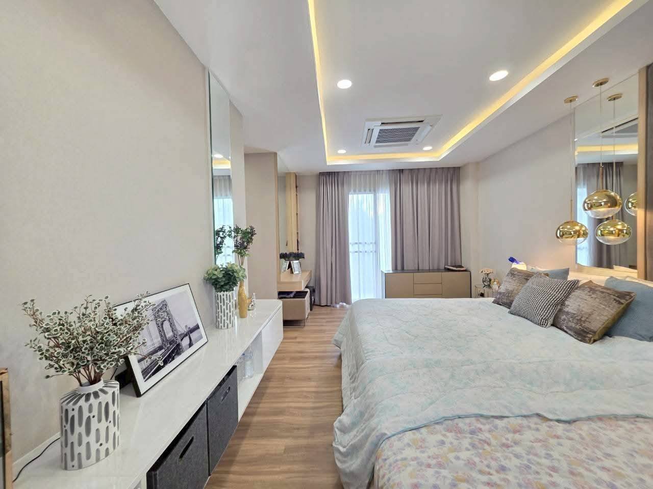 Modern luxury bedroom with mirrored walls, gold pendant lights, and wooden flooring