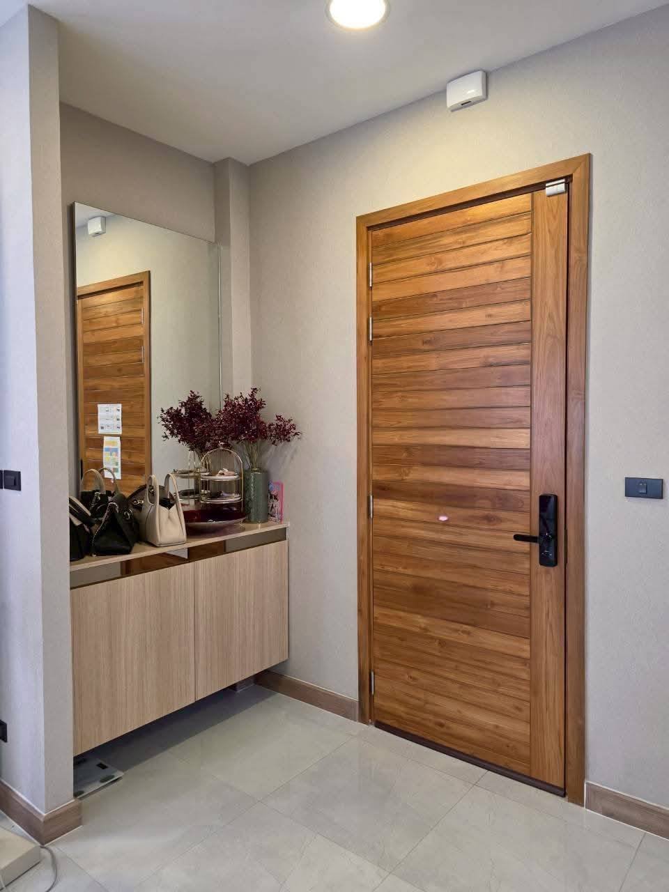Modern entryway with wooden doors, mirror, and decorative counter display