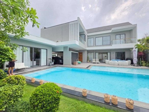 Modern mint green house with swimming pool and manicured garden landscaping