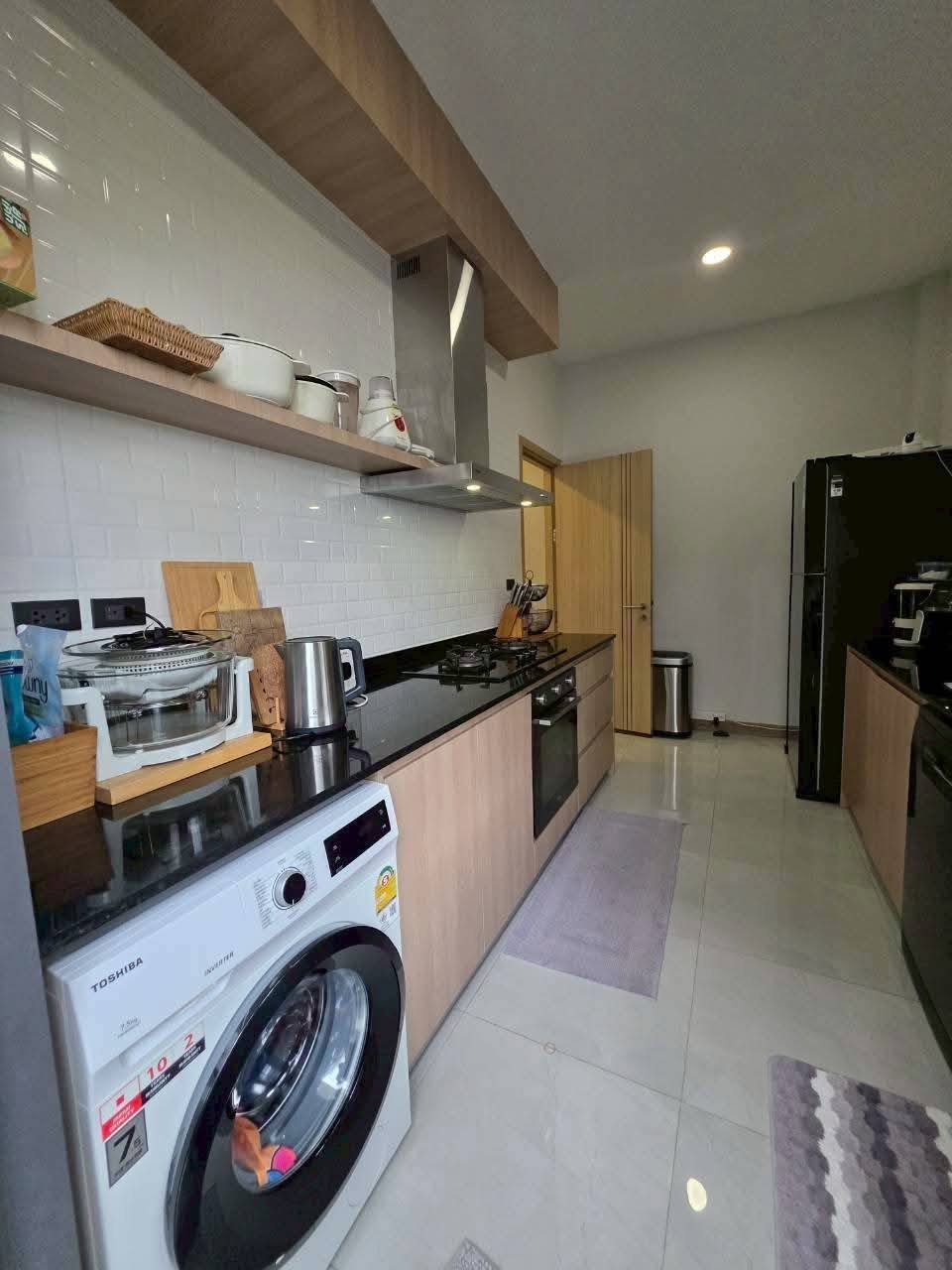 Modern kitchen with white subway tile backsplash, wood cabinets, stainless steel appliances