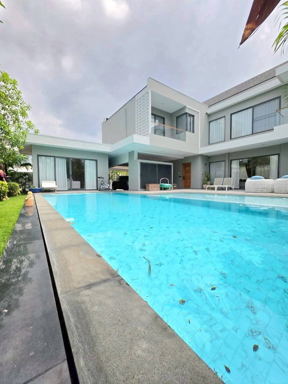 Modern minimalist house with swimming pool and manicured lawn